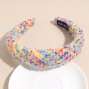 Detail of multi-color thick braided plush headband showing the textured hand made label