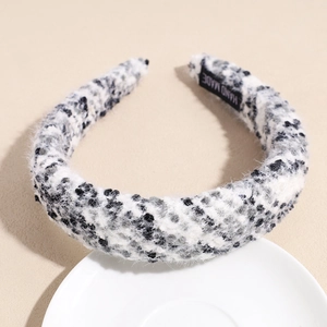 Detail view of plush black and white headband texture with a woven HAND MADE label