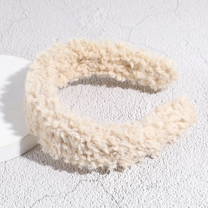 Close-up of fluffy beige faux shearling wide headband with soft teddy fleece texture
