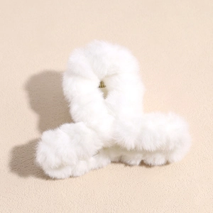Détail d'une pince à cheveux en fausse fourrure blanche et métal doré
