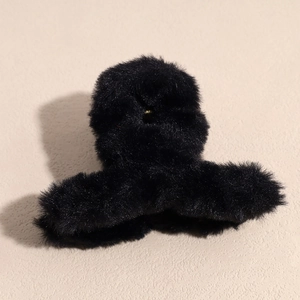 Détail d'une pince à cheveux en fausse fourrure noire douce pour les styles d'hiver