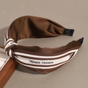Serre-tête en satin marron avec nœud et imprimé rayé sur fond gris minimaliste