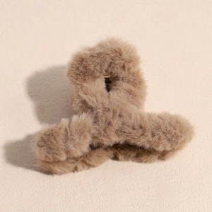 Détail d'une grande pince à cheveux en peluche kaki avec texture douce en fausse fourrure