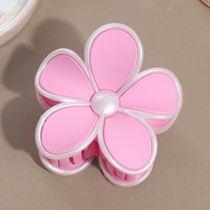 Détail de la pince à cheveux fleur rose mat avec bordure perlée blanche et design Y2K