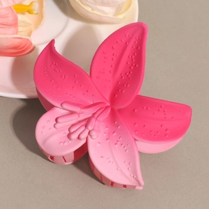 Detail of matte gradient lily hair claw with textured petals and morning dew effect