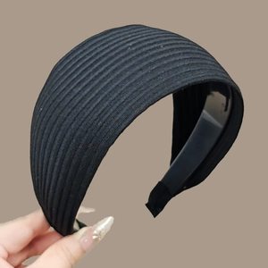 Detail of black wide knit headband showing ribbed fabric texture and elastic band