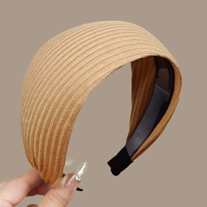 Close-up of khaki wide knitted headband with vertical stripes and non-slip inner teeth