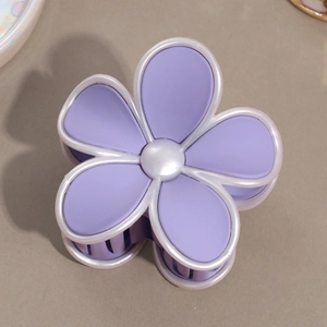 Détail d'une pince à cheveux fleur violette mate avec perle et bordure nacrée élégante