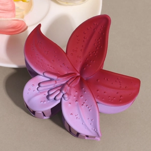 Detailed macro view showing the frosted gradient purple texture of the lily flower hair claw