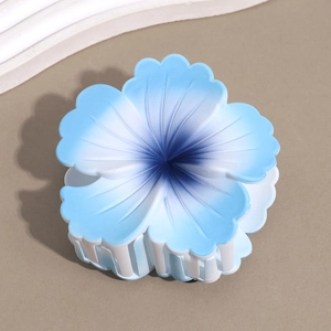 Detail of blue gradient plumeria hair claw clip with matte finish on sandy background