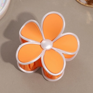 Détail de la pince à cheveux mate en forme de fleur orange et blanche à cinq pétales