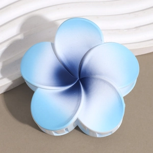 Macro view of blue gradient frangipani hair claw clip with matte finish and white teeth