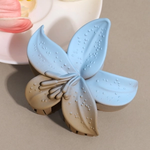 Detail of flower hair claw clip with blue and brown gradient finish and dotted texture