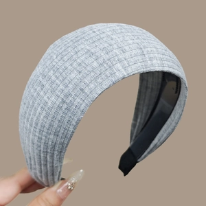 Detail of gray knitted headband showing anti-slip inner teeth and textured fabric