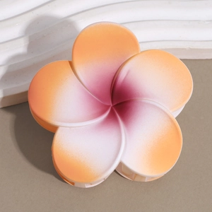 Macro detail of the orange and pink gradient plumeria hair claw clip with matte finish