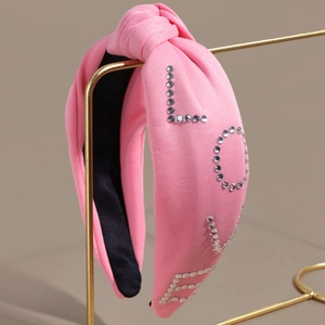 Pink knitted knotted headband with silver rhinestone LOVE lettering and non-slip lining