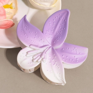 Close-up of matte purple lily flower hair claw clip with delicate frosted petal texture