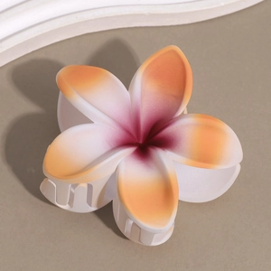 Macro detail of matte frosted plumeria flower hair claw with gradient color finish