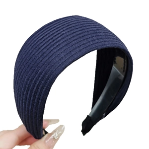 Wide navy blue knitted headband with ribbed texture for high crown styling and secure grip