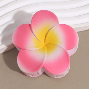 Detail of matte frangipani hair claw clip with pink gradient petals and yellow center