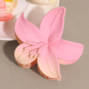 Macro detail of matte resin lily hair claw clip with pink gradient and non-slip texture