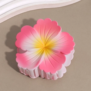 Top view of a matte pink gradient frangipani flower hair claw clip with yellow center