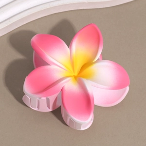 Macro shot of matte gradient pink and yellow plumeria flower hair claw clip hair accessory