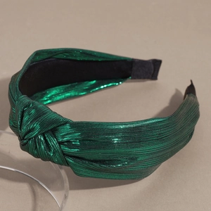 Détail du tissu métallique vert émeraude noué sur un bandeau large festif élégant