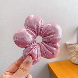 Detail eines rosa Satin-Plaid-Blumenschrunchies mit Metallglanz und gepolstertem Design