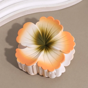 Close-up of frosted gradient frangipani hair claw with orange and green floral detail