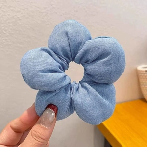 Handgehaltener hellblauer karierter Blumen-Scrunchie mit weichen 3D-Stoffblütenblättern