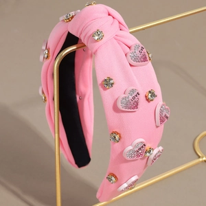 Détail du serre-tête large rose noué avec strass et ornements de cœur LOVE