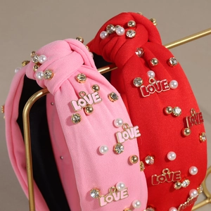 Knotted headband with pearls, rhinestones and LOVE pendant in pink and red tones