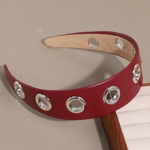 Détail d'un serre-tête large en cuir PU rouge avec œillets métalliques et rivets évidés