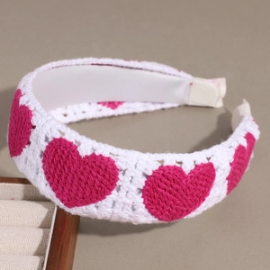 Dettaglio macro della fascia in maglia bianca con cuori rosa e fodera in raso morbido