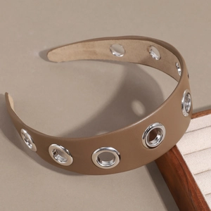 Gros plan d'un serre-tête en cuir PU marron avec rivets métalliques et doublure antidérapante