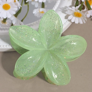 Makro-Detail der hellgrünen Blumen-Haarklammer mit glitzerndem Finish und Schimmer