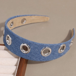 Detail of wide denim headband with silver metal rivets and hollow grommets texture