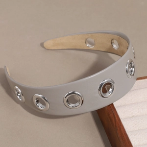 Détail d'un serre-tête en cuir PU gris avec œillets métalliques argentés et design évidé