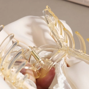 Elegante pinza per capelli in resina ambra con pizzo su uno sfondo di seta bianca morbida