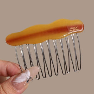 Detail of amber acetate hair comb with 12 silver metal teeth and France handmade gold logo