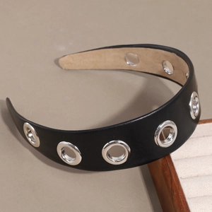 Serre-tête large en cuir PU avec œillets métalliques argentés sur un fond de studio