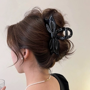 Large black glossy bow hair claw clip for elegant updo hairstyles and thick hair