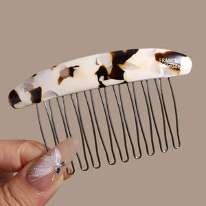Detail of tortoiseshell acetate hair comb with 15 metal teeth and handmade engraving