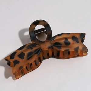 Detailed side view of large tortoiseshell bow claw clip with visible metal spring mechanism