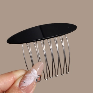 Close-up of elegant black acetic acid bow hair comb with polished metal teeth for hair styling