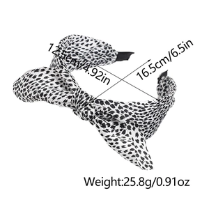 Detail showing dimensions and black and white spotted bow headband with inner comb teeth
