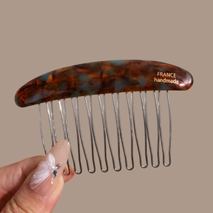 Detail of tortoiseshell hair comb with silver metal teeth and gold handmade stamp