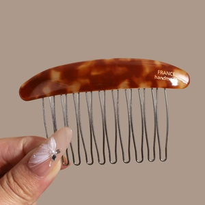 Detail of tortoiseshell acetate hair comb with France handmade text and metal teeth
