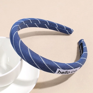 Detailed close-up of blue striped fabric headband with hello tag on a white ceramic cup